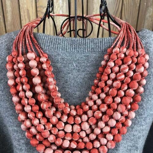 silkroad upcycled repurposed sari necklace in salmon on wire dress frame and gray sweater